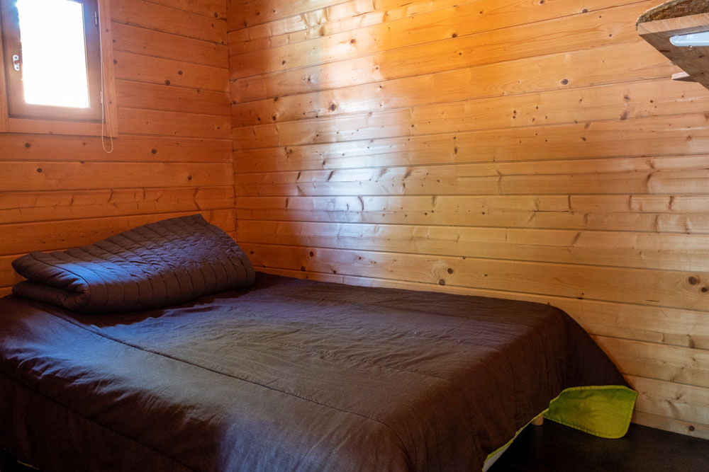 Location de chalets en bois. Vue intérieure. La chambre avec lit double.