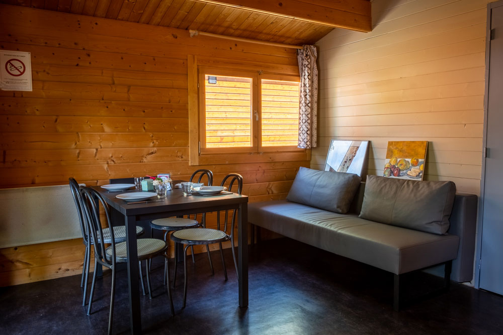 Location de chalets. Vue de l'intérieur. La pièce avec table de repas et canapé.